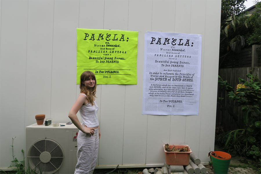 Girl standing next to display of the printed and embroidered wall hangings
