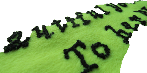 Black embroidery of letters on yellow fabric